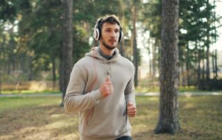 man-with-headphones-running-in-a-forest